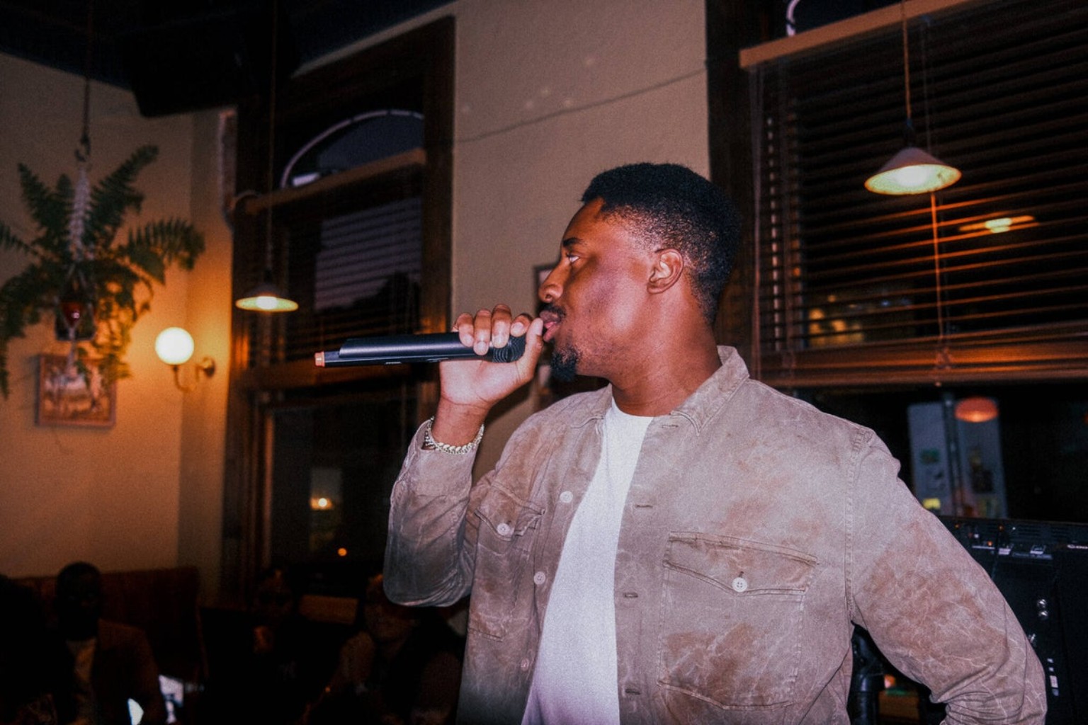 Daniel Olasoji hosting an evening event with a microphone
