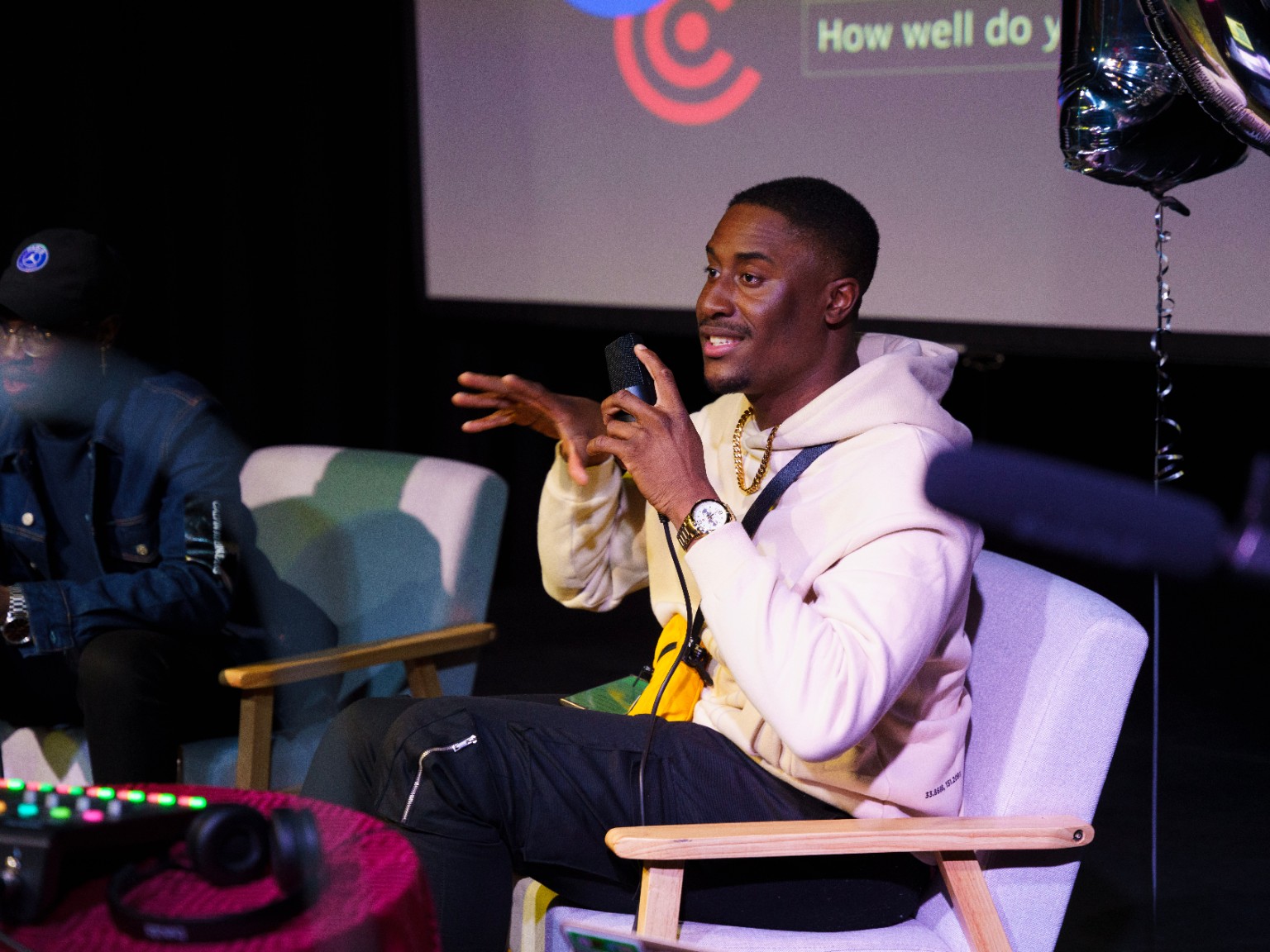 Daniel Olasoji speaking into a microphone during a live podcast recording
